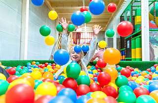 Child playing in the indoor fun park ball pool of the Sunstar Arosa