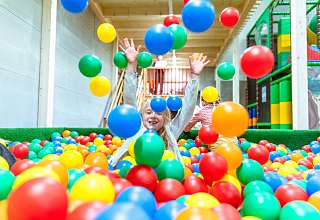 Child playing in the indoor fun park ball pool of the Sunstar Arosa